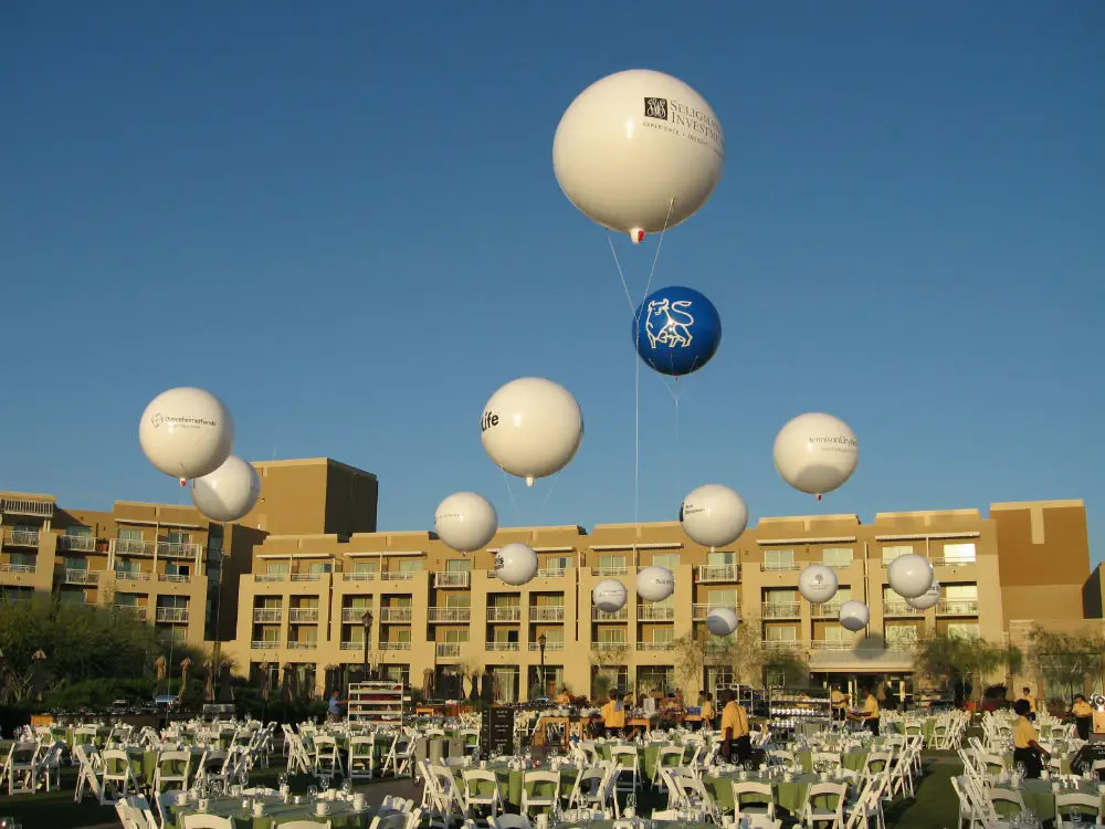 Cluster of logo helium balloons over a resort
